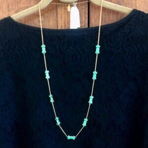 KATE SPADE gold tone bow necklace with green enamel.